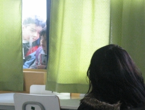 Niños viendo Melodrama Lo-Fi a través de una ventana del comedor de su colegio.